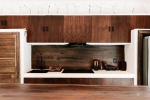 a kitchen with wooden cabinets and a stove top oven at Tulum Jungle Villa Tierra in Chemuyil