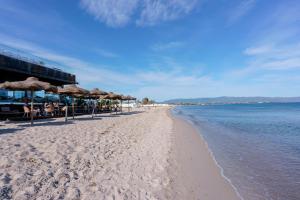 a sandy beach with umbrellas and the ocean at Paradise Home in Quartu SantʼElena