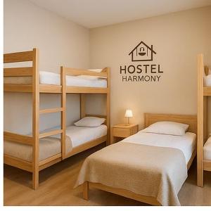 een kamer met twee stapelbedden en een hostel-mensheidsbord bij Hostel Harmony in Zhezdi