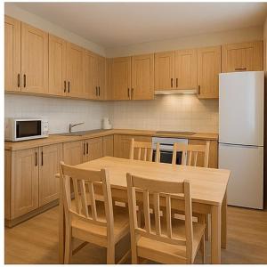 een keuken met een houten tafel en een witte koelkast bij Hostel Harmony in Zhezdi