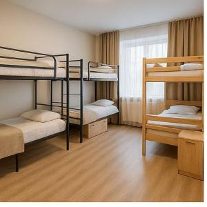 een kamer met 3 stapelbedden en een raam bij Hostel Harmony in Zhezdi