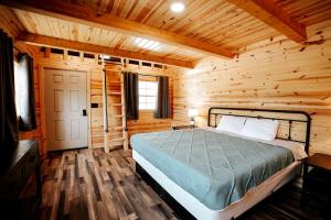 ein Schlafzimmer mit einem Bett in einer Blockhütte in der Unterkunft Stunning Wooden Cabin Nestled Amidst Trees in Rapid City, South Dakota in Rockerville