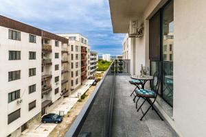 ナボダリにあるLago Retreat Apartamentの建物の上にテーブルと椅子が置かれたバルコニー