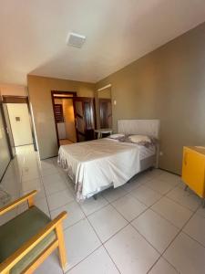 a bedroom with a bed and a bench in it at Duplex à 800 mts do Beach Park COM 5 suítes in Aquiraz