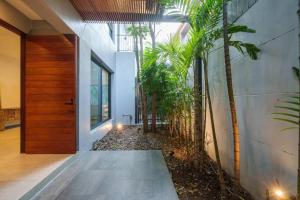 un pasillo con palmeras junto a un edificio en MonochromeDesignerPool Villa, en Ban Na Song