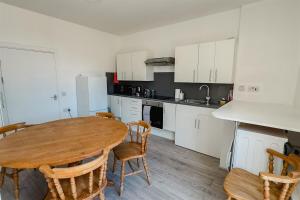a kitchen with a wooden table and chairs in it at Withernsea 2 bed apt and sofa bed in Withernsea