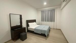 a bedroom with a bed and a mirror and a dresser at D'millenia Bangau Homestay in Kuching