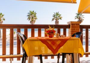 a table with a yellow table cloth on a balcony at FAMILY KIDS VILLAGE Riva dei Pini in Lido di Fermo