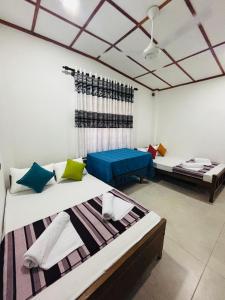 Habitación con 2 camas y sofá azul en Madiriya Forest Lodge, en Badulla
