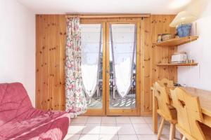 a living room with a sliding glass door and a table at La Foret des Rennes - Les Saisies in Les Saisies