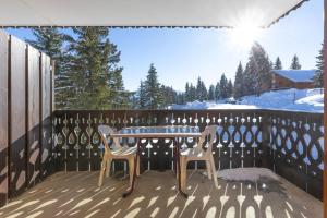 a table and chairs on a deck with the snow at La Foret des Rennes - Les Saisies in Les Saisies