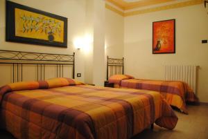 Hotel Ristorante la Siesta في Pietrapaola: غرفة نوم بسريرين ولوحة على الحائط