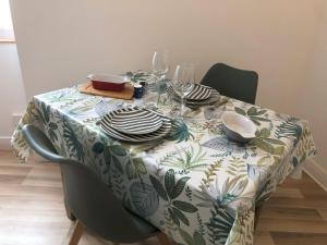 a table with a table cloth with plates and dishes on it at Villa Jean Pierre in Pougues-les-Eaux