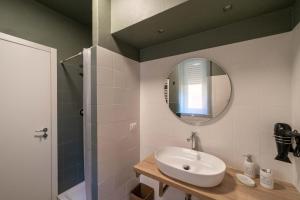 un bagno con lavandino e specchio di A Due Passi dal Mare Stanza N3 a Porto Ercole