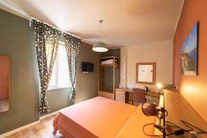 una camera con tavolo, scrivania e finestra di A Due Passi dal Mare Stanza N3 a Porto Ercole