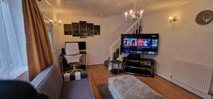 a living room with a couch and a flat screen tv at Detached 3 Bedroom House in Leicester with Private Parking in Leicester