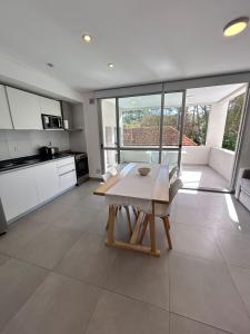 a kitchen with a wooden table in a room at Edificio Cerezo 77 by D&G in Carilo