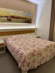 a bedroom with a bed with a pink bedspread and a painting at la bussola gallipoli in Gallipoli