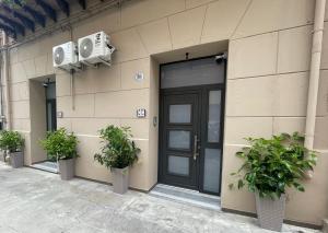 a building with a door and two potted plants at Casta Diva Fervore Apartments Self Check-in in Palermo