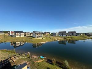 an aerial view of a lake with houses at Still Waters - Luxury Lakeside Retreat with Hot Tub in Warmwell +80 photos