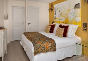 a bedroom with a large white bed and yellow walls at La Maison des Augustins 4 stars Spa et Fitness in Avignon