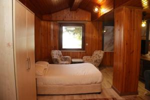 a bedroom with a bed and two chairs and a window at Grand Koru Hotel Beach in Yalova