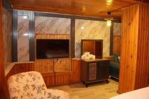 a room with a television and a chair and a table at Grand Koru Hotel Beach in Yalova