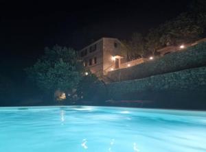 a swimming pool at night with a building in the background at Stone House Bay View - Kaštel Lukšić in Kaštela