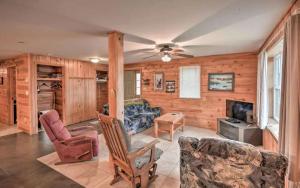 a living room with wooden walls and a ceiling fan at Charming Four-Bedroom Cabin Rental near Long Lake in Aroostook County, Maine in Lavertue