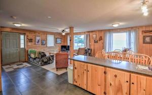a kitchen and dining room with a table and chairs at Charming Four-Bedroom Cabin Rental near Long Lake in Aroostook County, Maine in Lavertue
