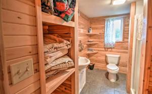 a log cabin bathroom with a toilet and a sink at Charming Four-Bedroom Cabin Rental near Long Lake in Aroostook County, Maine in Lavertue