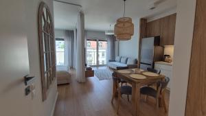 a kitchen and living room with a table and chairs at Luxurious Cinnamon Apartment, self check-in 24h, free parking, air-conditioning in Poznań