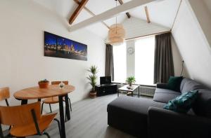 a living room with a couch and a table at Green City Apartement in Alkmaar