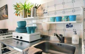 a kitchen with a sink and a counter with dishes at Green City Apartement in Alkmaar