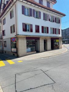 a large white building with red windows on a street at Andaman 1 Zimmer Wohnung in Lucerne