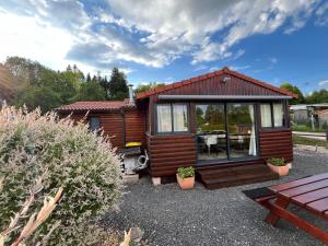 mała chata z dużym oknem i patio w obiekcie Le Chalet de la Folie w mieście Corcieux