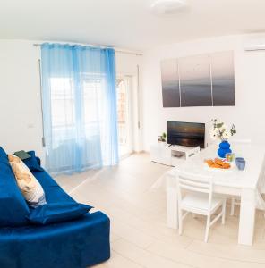 a living room with a blue couch and a table at DanysHome Circe davanti al mare in Terracina