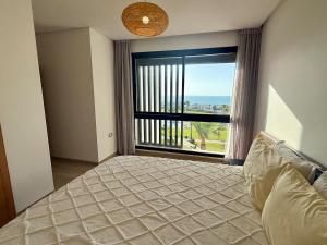 Un dormitorio con una cama y una ventana grande. en Sea View Apartment & Swimming Pool, en Sidi Bouqnadel 24 fotos más
