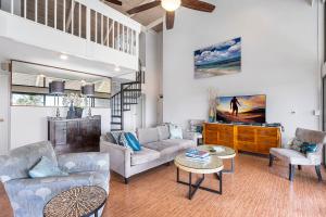 a living room with two couches and a tv at Big Island Keauhou Punahele A301 by Coldwell Banker Island Vacations in Kailua-Kona