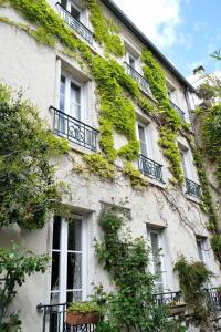 a building covered in ivy with windows and plants at Country house in Paris in Boulogne-Billancourt