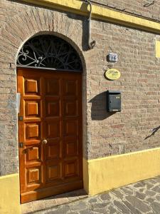 a wooden door on a brick building with a sign on it at Affittacamere Il Cortile in Chiaravalle