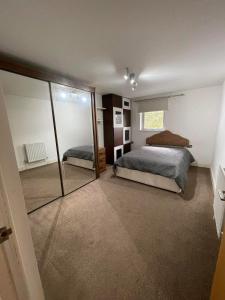 Un dormitorio con dos camas y un gran espejo. en Beautiful room- private bathroom, en Harrow