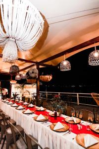 a long table in a restaurant with white tables and chairs at Hotel Peten in Flores +78 photos
