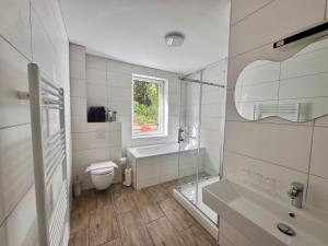 a white bathroom with a toilet and a sink at Ferienwohnung Hubertus in Blankenstein +27 photos