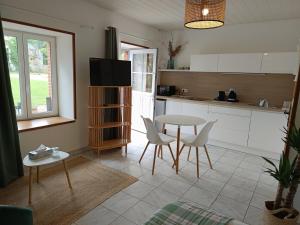 a kitchen with a table and chairs and a table at Studio équipé, proche aéroport in Bouguenais