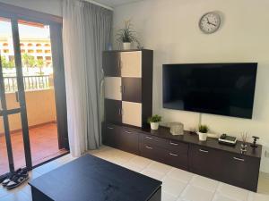 a living room with a flat screen tv on a wall at Golden Mile Getaway - Las Americas Tenerife in Playa de las Americas