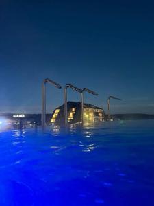 una piscina de agua frente a un edificio por la noche en Fruške 202 studio apartman, en Vrdnik