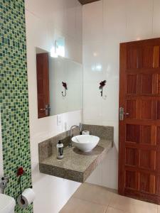 a bathroom with a sink and a mirror at Chalé Aconchego da Paz - Chalé 2 in Lavras Novas +18 photos