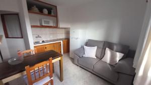 un soggiorno con un divano, un tavolo e una cucina di Uviya 2 a Famara