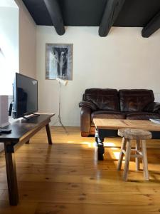 a living room with a leather couch and a table at Le gîte Rodary in Grandrif